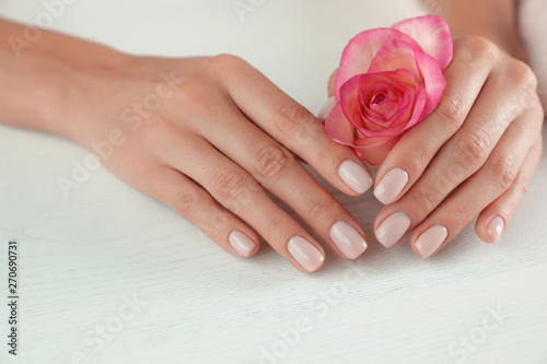 Woman holding flower at table  closeup. Spa treatment