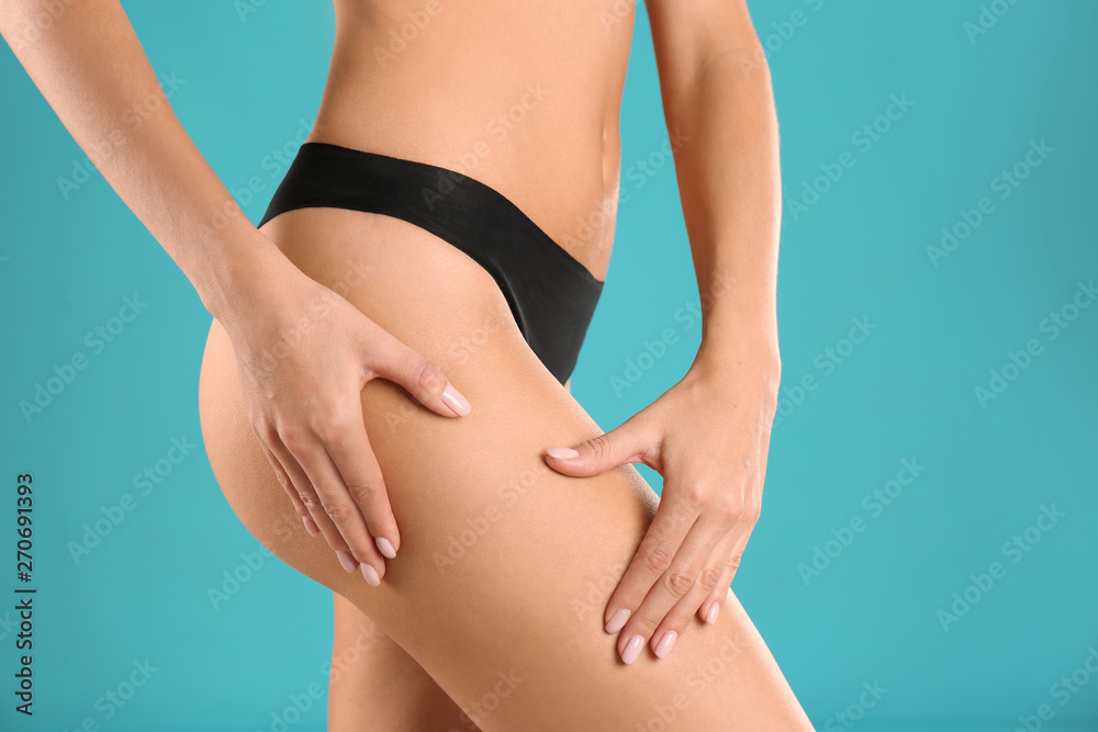 Closeup view of slim woman in underwear on color background. Cellulite problem concept