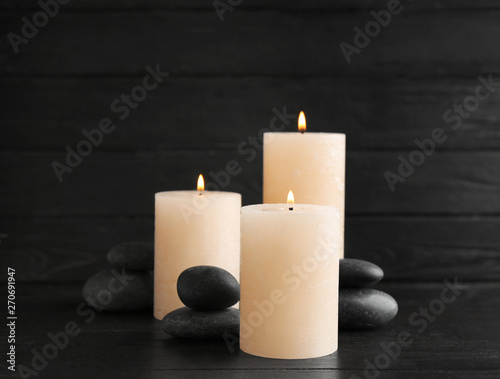 Burning candles and spa stones on table. Space for text