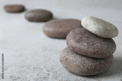 Stacked spa stones on grey table. Space for text