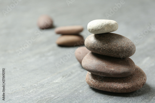 Stacked spa stones on grey table. Space for text