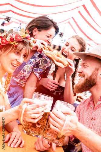 Gruppe von Jungen Menschen im Festzelt beim Feiern und Bier trinken und spaß haben photo