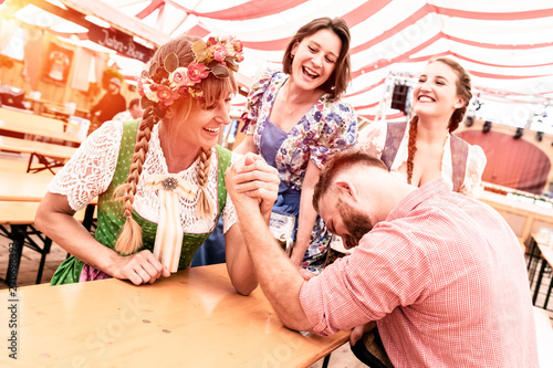 Freunde auf dem Volksfest im Festzelt Bierzelt beim Armdrücken und Bier trinken haben Spaß