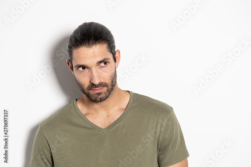 Expressive young man on white background pointing at the camera and laughing