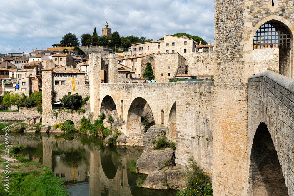 Romanesque bridge across the river Fluvia with arches and defence towers in Besalu, Spain