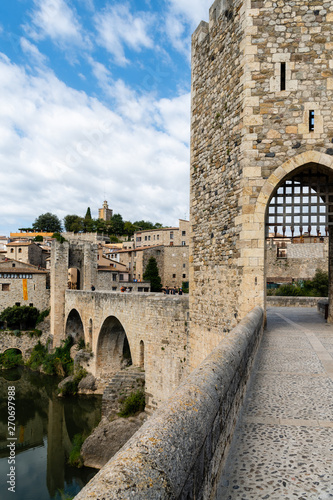 View along romanesque bridge over the Fluvia river  arches and defence towers showing