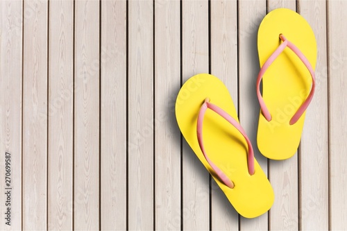 Yellow rubber sandals flip flops on wooden background