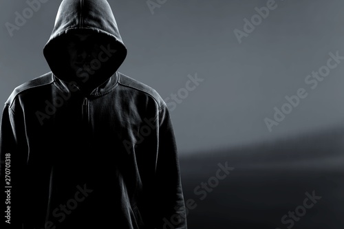 Thief in black clothes on grey background photo