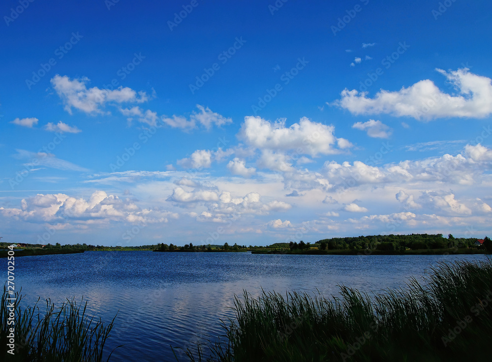 blue sky and clouds are touching the horizon on the lake