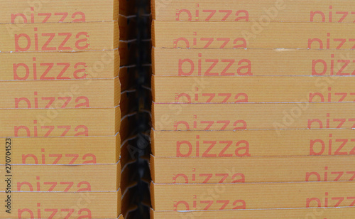 Pile of beige cardboard pizzaboxes with red text photo