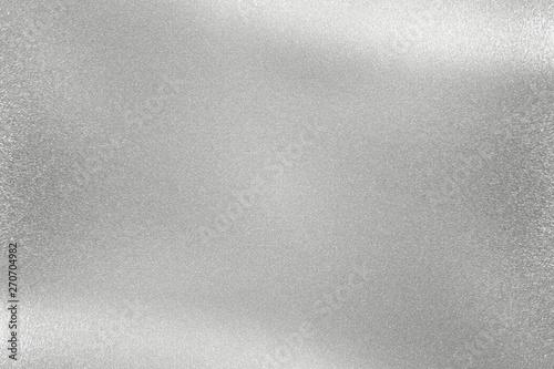 Glowing polished silver metal wall, abstract texture background