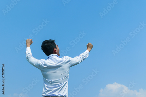 happy Asian business man with arms raised