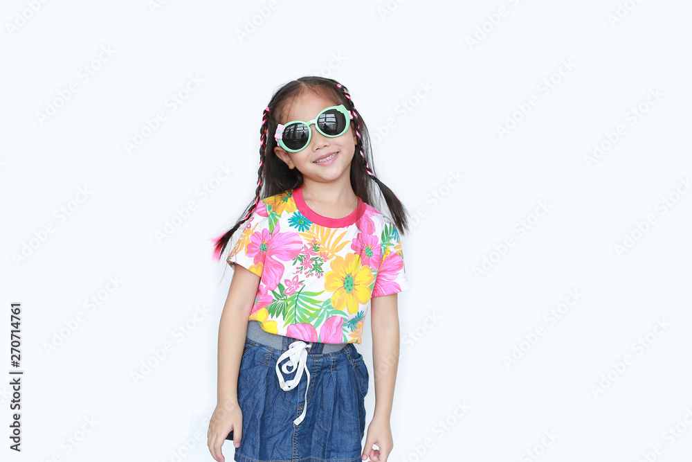 Smiling little Asian child girl wearing a floral pattern summer dress and sunglasses isolated on white background. Summer and fashion concept.