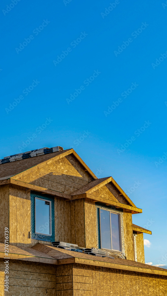 Vertical frame Exterior of a house under construction lit by sunlight on a sunny day Vertical frame Exterior of a house under construction lit by sunlight on a sunny day