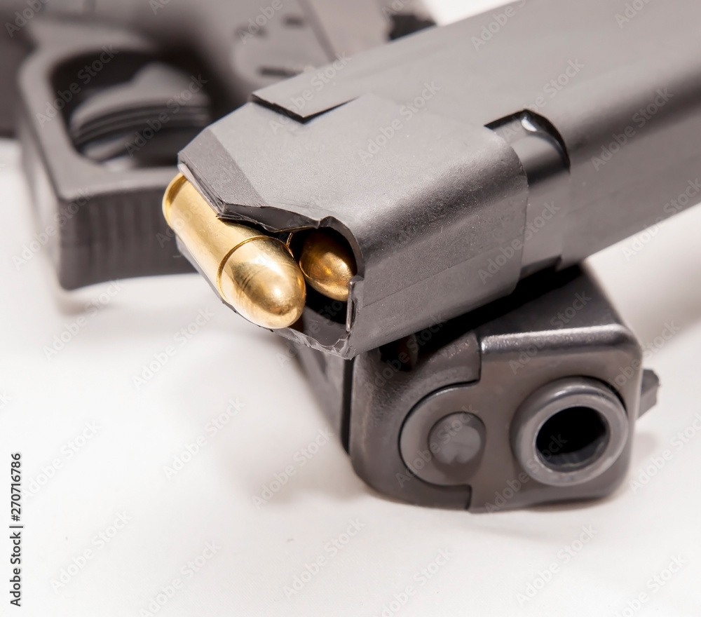 A black 9mm pistol with a pistol magazine loaded with full metal jacket
