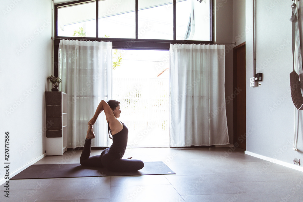 Young woman practicing yoga in gray background.Young people do yoga indoor Young woman practicing yoga in gray background.Young people do yoga indoor