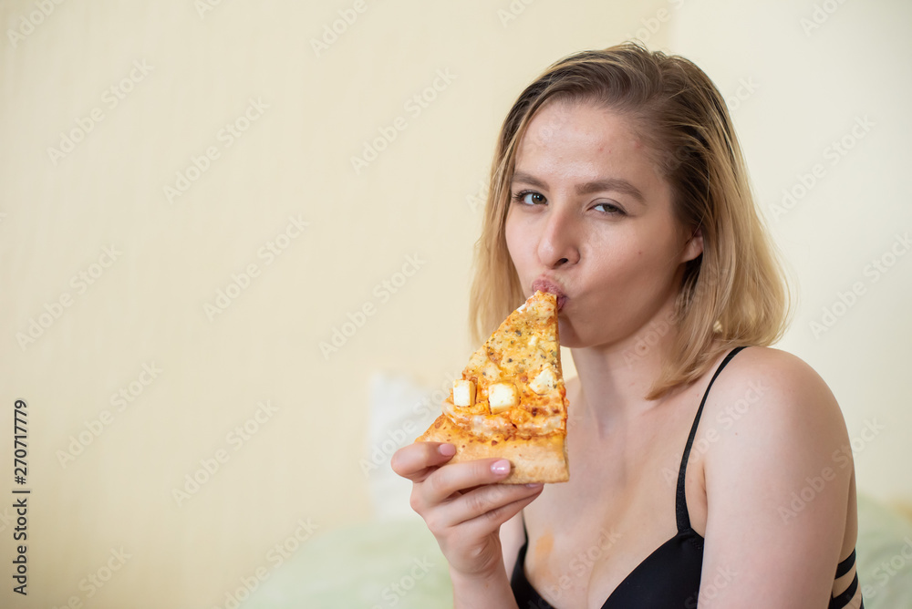 European girl with short hair posing with pieces of delicious pizza.