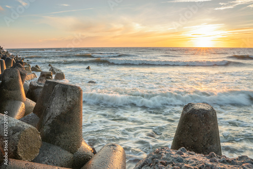  View from the breakwater at sunset over the Baltic Sea. Beautiful waves, the sky at sunset. Regime time for the photographer. Long exposure photography.