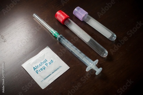 Blood taking kit, Empty syringe with needles, blood container tube and alcohol swab against isolated white background, medical concept