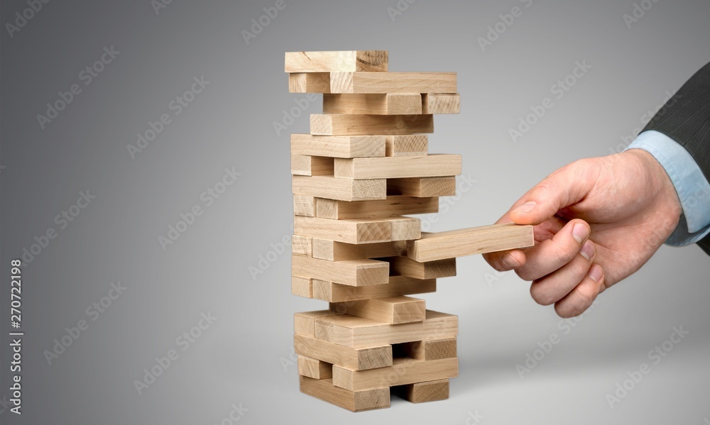 Wood blocks stack game with Hand on background,Conceptual of Teamwork, Strategy and Vision. Wood blocks stack game with Hand on background,Conceptual of Teamwork, Strategy and Vision.