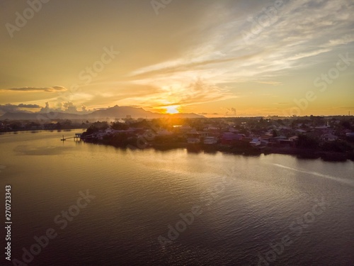 scenic aerial view of Sarawak River during sunset with Gunung (mountain) Serapi at the background