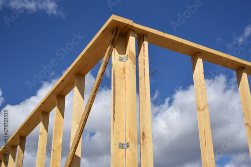 Wood frame residential building under construction.Building construction, wood framing structure at new property development site.new home currently under construction against blue sky.mortgage, loan.