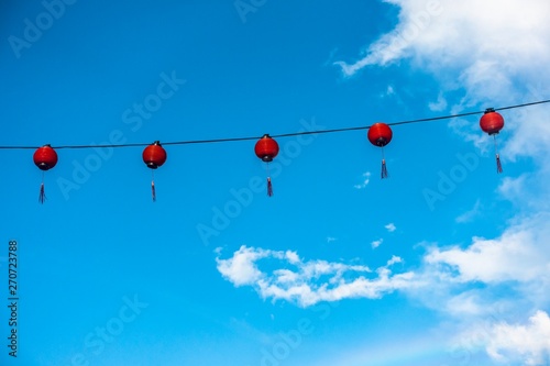 Traditional Chinese Lantern isolated against blue sky. The word on lantern is Ïzakaya" which means It is a compound word consisting of i (to stay) and sakaya (sake shop)