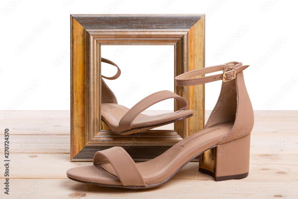 a pair of women's shoes and a picture frame on wooden boards, the concept of shoes