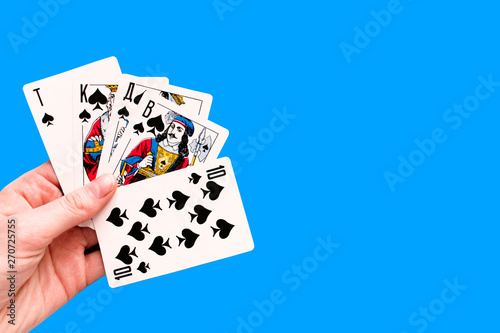 Playing card. Hand with card playing poker .close up of male hand with playing cards and chips at home. Pocker game. Casino cards as background. Concept for games, gambling in casino and sports poker.
