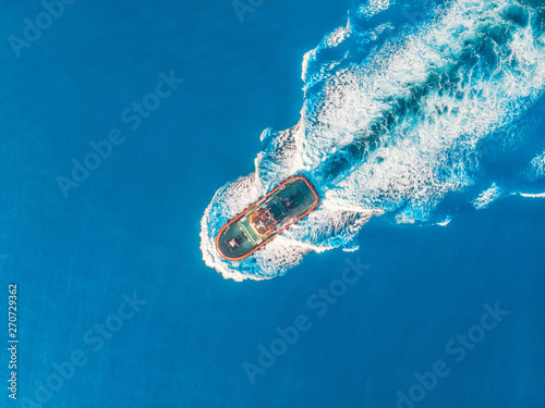 Tugboat blue sea port. Aerial top view