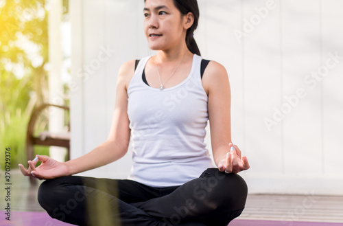 Beautiful asian woman sitting practicing doing yoga meditating after waking up at home,Healthy and lifestyle concept