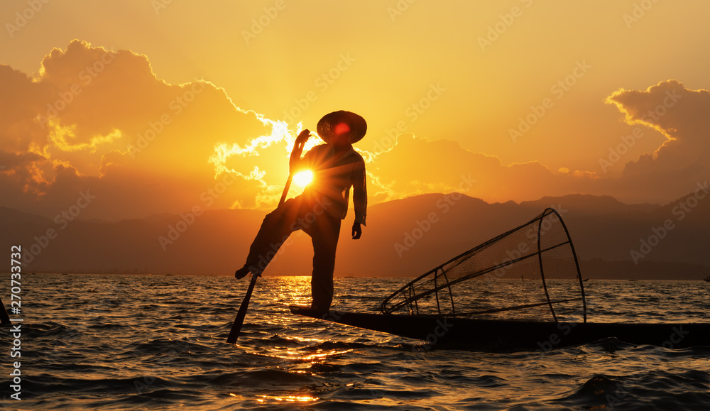 Silhouettes fisherman fishing at lake. silhouette man on boat on river sunset at Inlay Myanmar Local people asian.