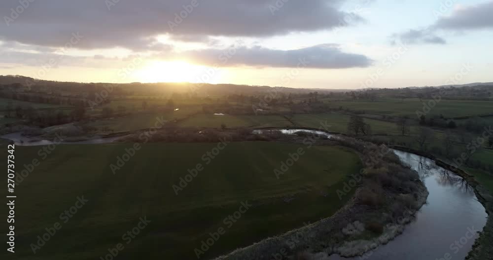 Aerial shot of sunrise over a meandering river in the English countryside. Aerial shot of sunrise over a meandering river in the English countryside.