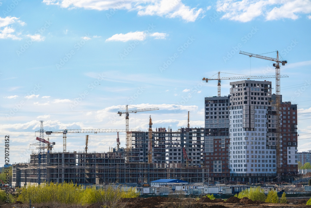 image of a tower cranes at the construction site of a residential house
