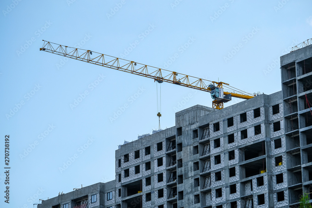 image of a tower crane at the construction site of a residential house