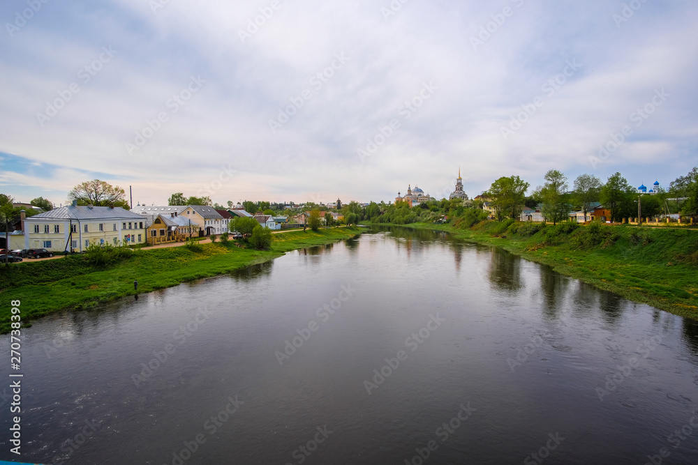 Panorama of Torzhok with views of the river and dwelling houses and a church standing in the distance