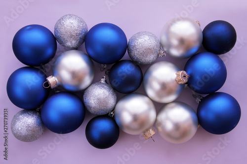 Christmas balls in blue and white colors on lilac background