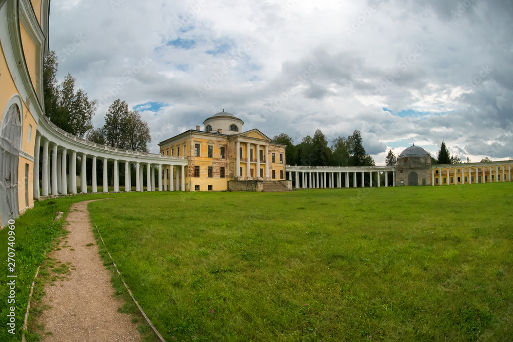Fototapeta premium Architectural ensemble Manor Znamenskoye-Rayok. The manor house and the circular colonnade connecting it with the side wings (carriage and greenhouse) and the main gate opposite to it.
