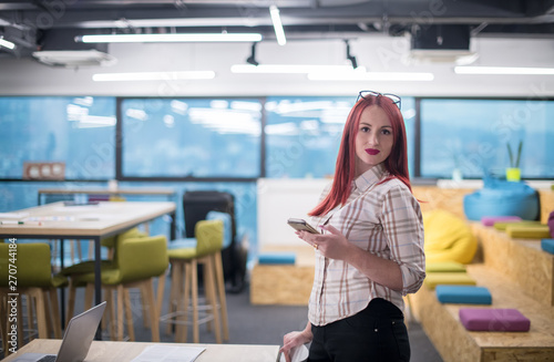 redhead businesswoman using mobile phone at office © .shock