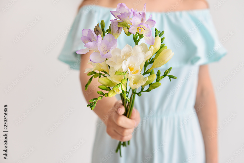 Woman with beautiful freesia flowers on light background, closeup Woman with beautiful freesia flowers on light background, closeup