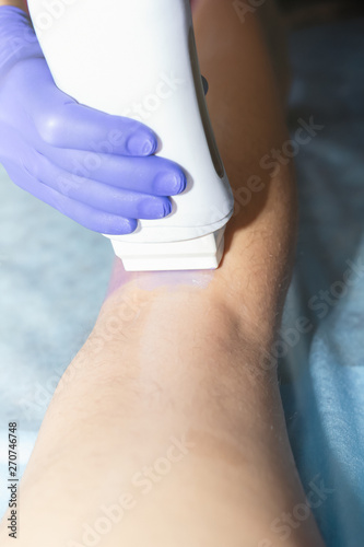 Woman having hair removal procedure on leg with wax depilatory in salon. Depilation concept.