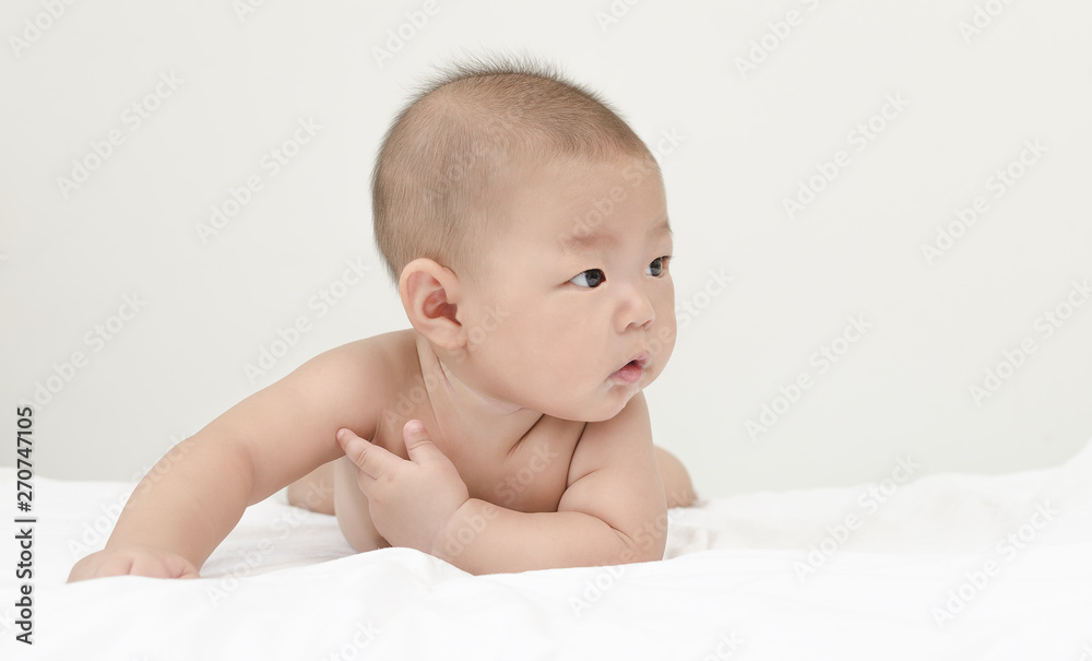 portrait of little small asian baby infant relaxing after bath looking to the right side with copy space portrait of little small asian baby infant relaxing after bath looking to the right side with copy space