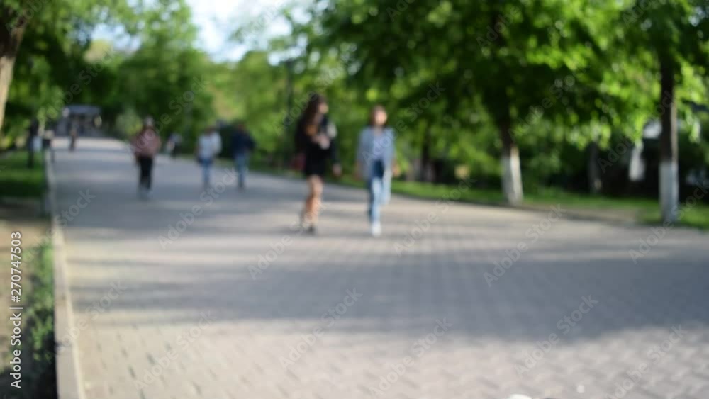 People on a blurred background are walking on the cobblestones People on a blurred background are walking on the cobblestones