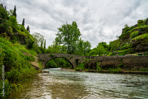 Obraz na płótnie Montenegro, Ancient stone bridge called stari most na ribnici over clean river ribnica in green forest podgorica city w salonie