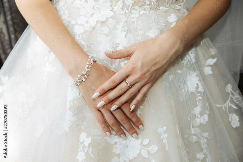 Beautiful bride's hands on the dress. Fingers with golden rings. Wedding morning. Beautiful bride's hands on the dress. Fingers with golden rings. Wedding morning.