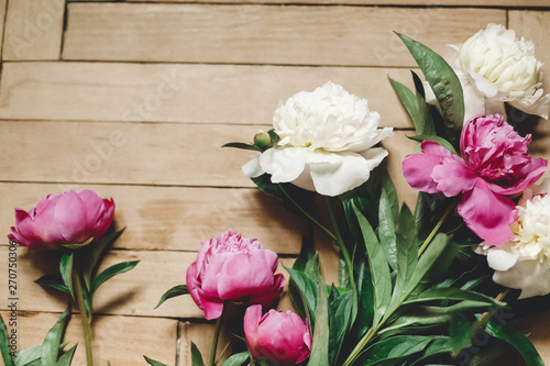 Beautiful pink and white peonies on rustic wooden floor , flat lay. Floral decor and arrangement. Gathering flowers. Rural still life, countryside flowers © sonyachny