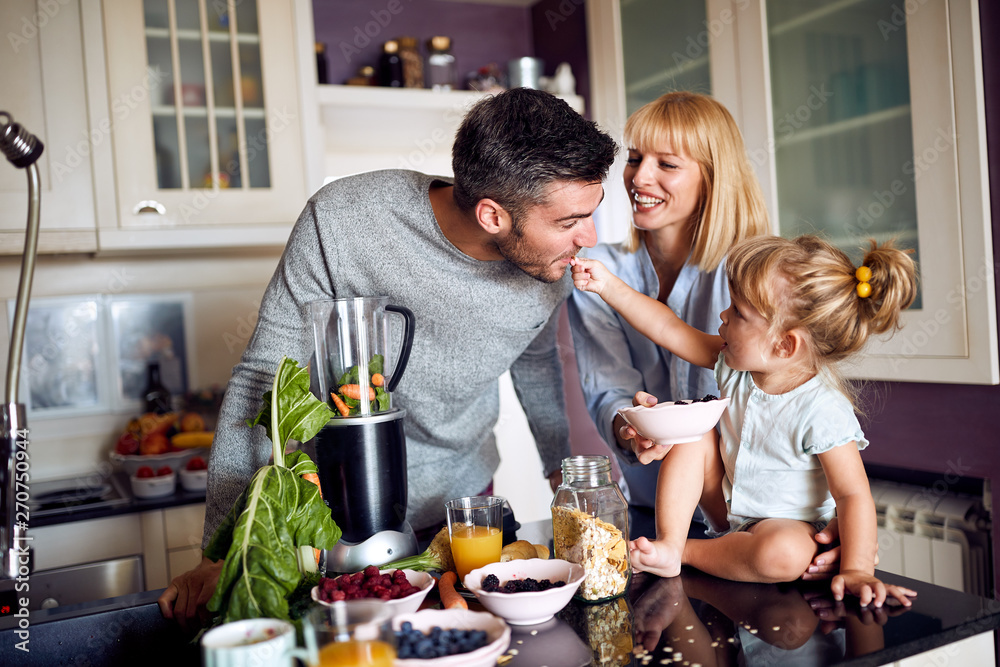 Child with parents having fun during breakfast Child with parents having fun during breakfast