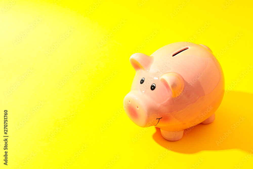 Happy piggy bank on yellow background, space for text. Finance, saving money