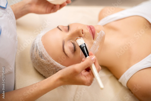 Beautiful woman visiting cosmetologist for mask therapy
