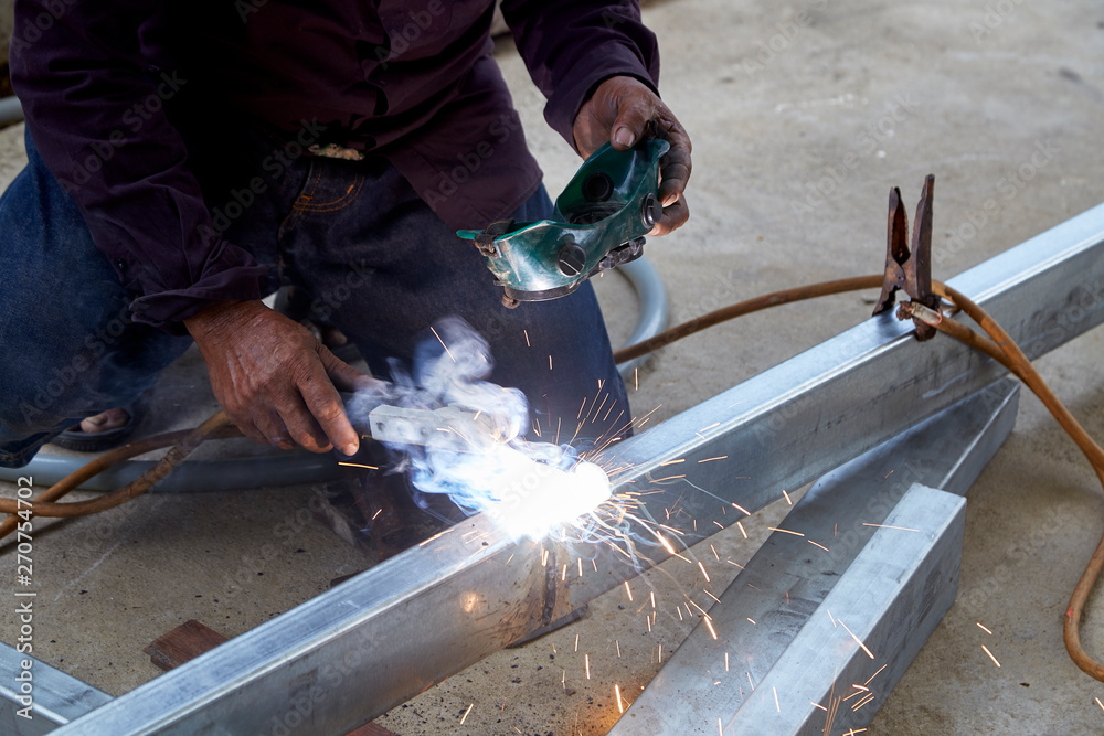 The welders are welding steel in the factory